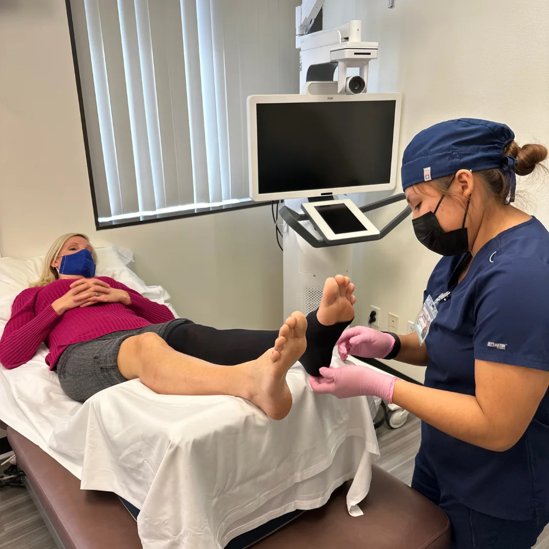 compression stockings help with venous disease, mediack assistant helping patient adjust her compression stockings